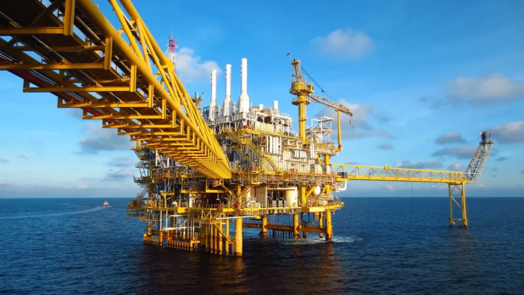 Oil Rig in the ocean backed by a blue sky.