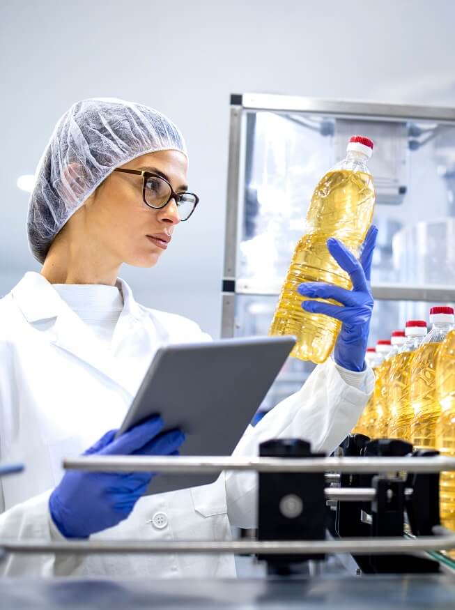 Woman is Inspecting oil bottles in laboratory