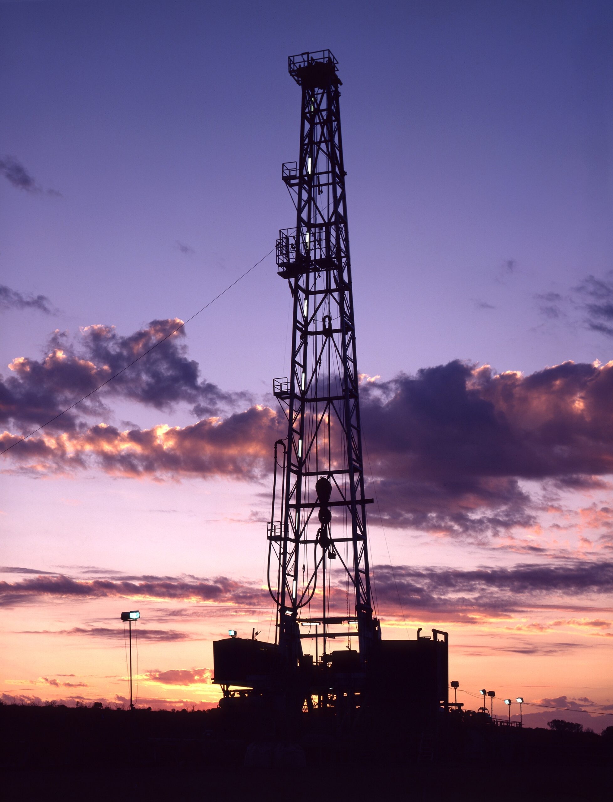 Oil rig silhouetted against sunset